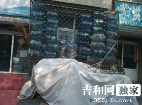 长春一居民将饮水塑料桶当做防风墙避寒