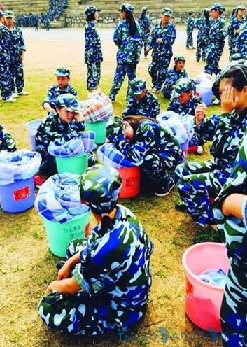湖南高校新生裹棉被晒太阳 罚头顶塑料桶跑圈