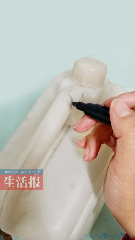 在塑料桶手柄靠近瓶盖的地方，用水性笔画出一条线。