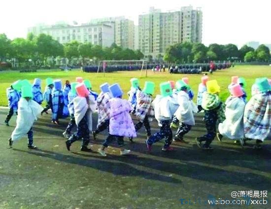 学校新生军训被罚操场裹棉被晒太阳：头戴塑料桶跑操场(图)