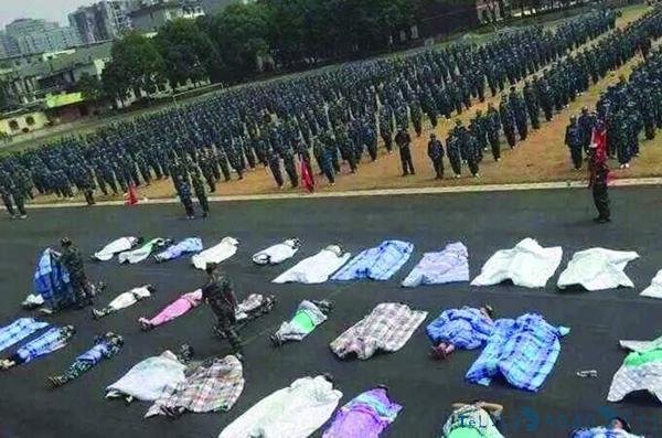 学校新生军训被罚操场裹棉被晒太阳：头戴塑料桶跑操场(图)