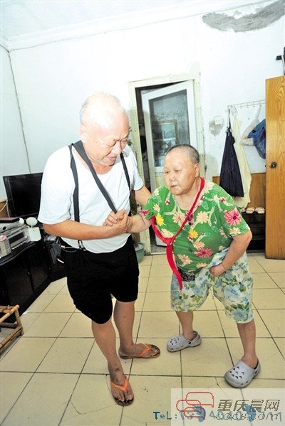 杨度学在家扶瘫痪13年的妻子万启加练习走路。