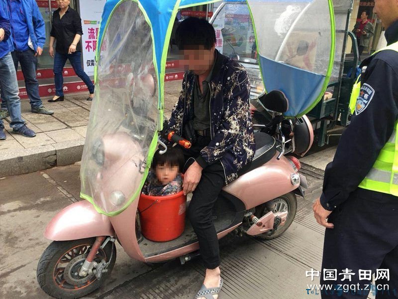 为了骑电动车能带孩子 竟然把幼童放进塑料桶