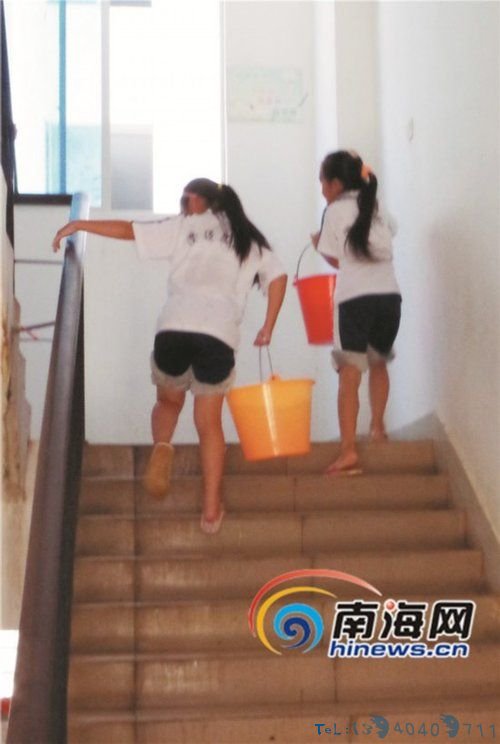 澄迈思源实验学校两名小学生提水上楼。