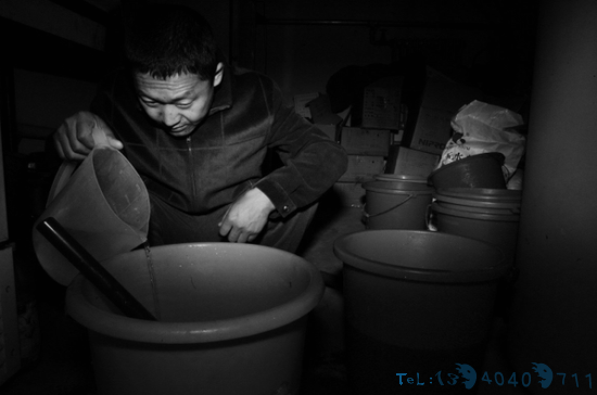 自助透析室发起人魏强在用塑料桶自行调配透析液。